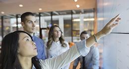 Three people looking up at a screen with an instructor